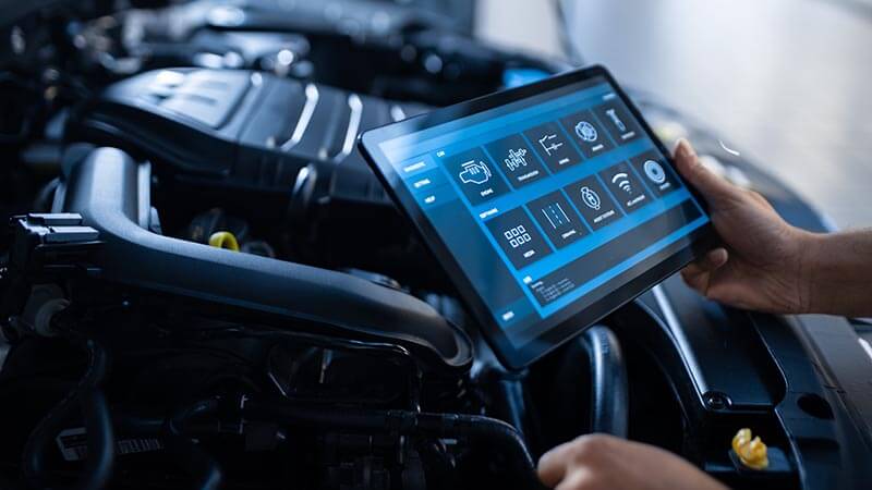 Mechanic Uses a Tablet Computer with a Futuristic Interactive Diagnostics Software